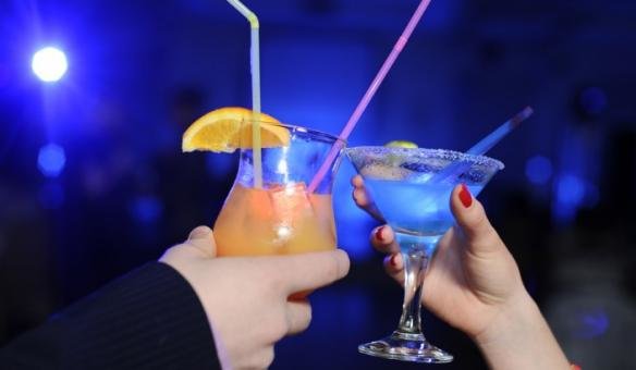 Hands make a toast with colorful cocktail drinks