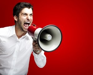 Man yelling into a megaphone with red background