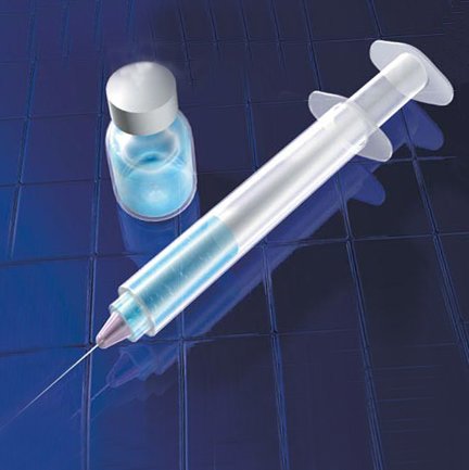 A syringe and vile sit on a table together