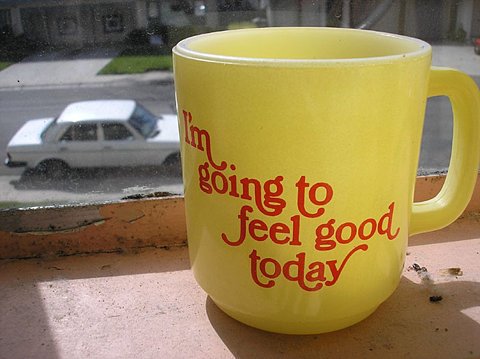 Yellow coffee mug on ledge reads I'm going to feel good today