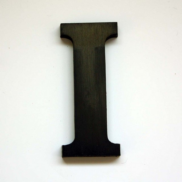 Wooden letter I painted black on a white background