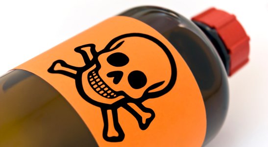 A brown bottle with orange label of skull and bones