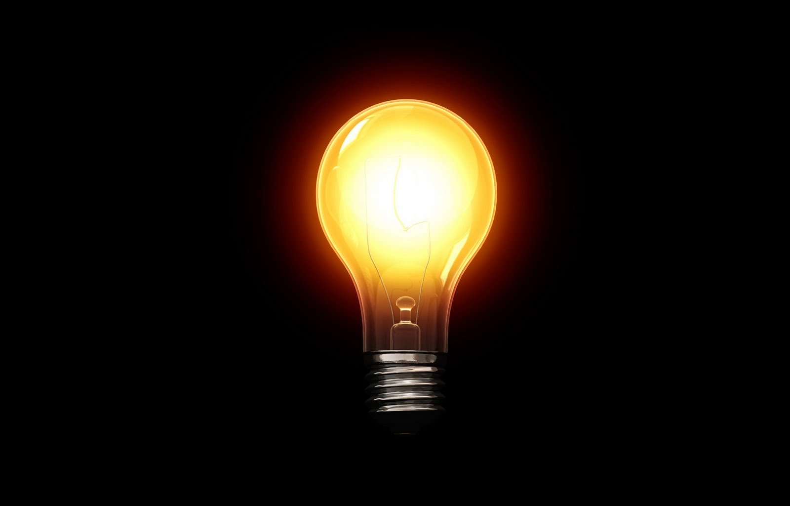 Lit up yellow-ish light bulb on a black background