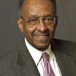 Portrait of Walter E. Williams in grey suit and purple tie