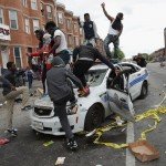 Several demonstrators riot the streets of Baltimore by destroying cop car
