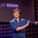Sally Kohn speaking live with name on TV in background