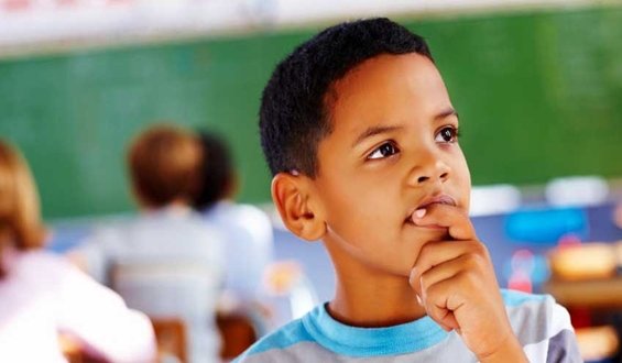 Young boy ponders with classroom classmates in background