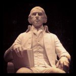 White stone statue of James Madison holding a book