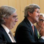 John Kerry smiles and claps at a conference