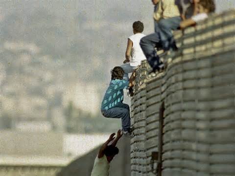 Immigrants climbing over Mexican border