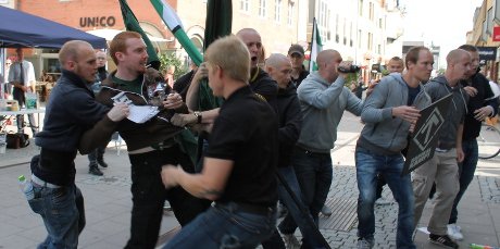 Men hold back another man during a riot movement