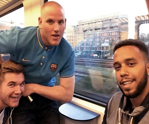 Three men laughing and smiling on train