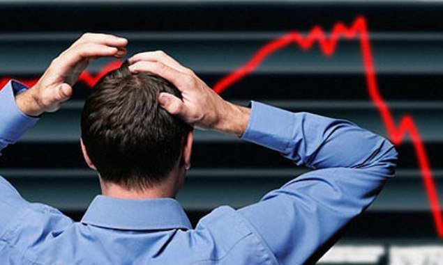 Man stands holding head in frustration at stock market decrease