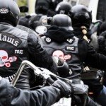 Several motocycle bikers wearing black Outlaws jackets