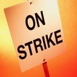 Picket sign reads On Strike